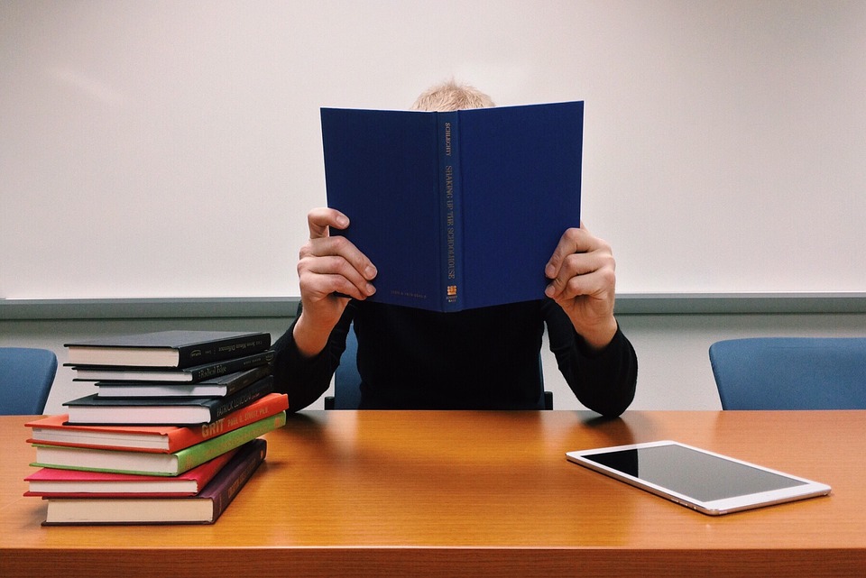 Persona sentado, leyendo un libro